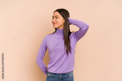 Young colombian woman isolated on beige background tired and very sleepy keeping hand on head.