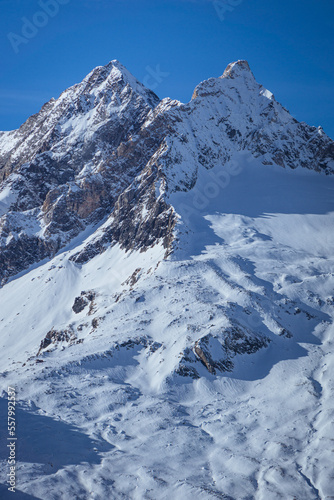 The mountains, glaciers and snow of Val Malenco, during a sunny winter day, near the village of Chiesa in Valmalenco, Italy - December 2022.