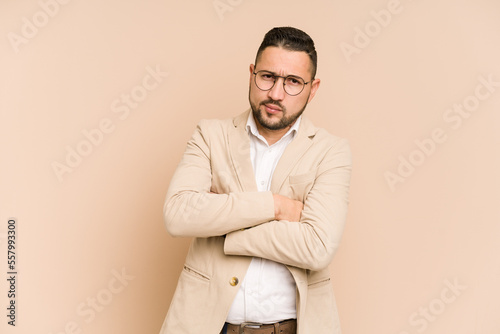 Adult latin business man cut out isolated frowning face in displeasure, keeps arms folded.