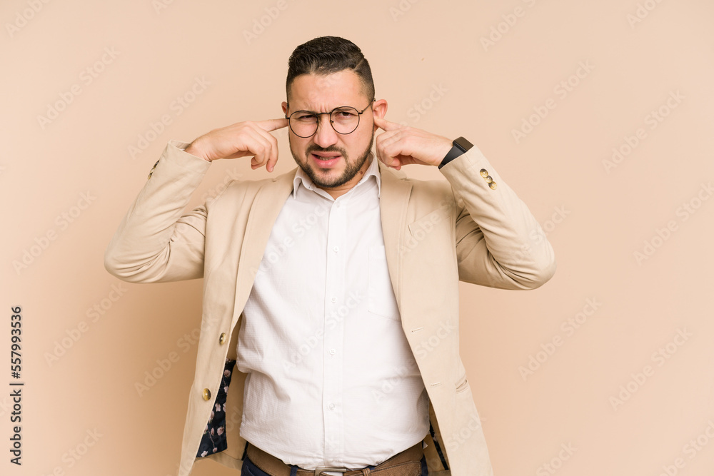 Adult latin business man cut out isolated covering ears with fingers, stressed and desperate by a loudly ambient.