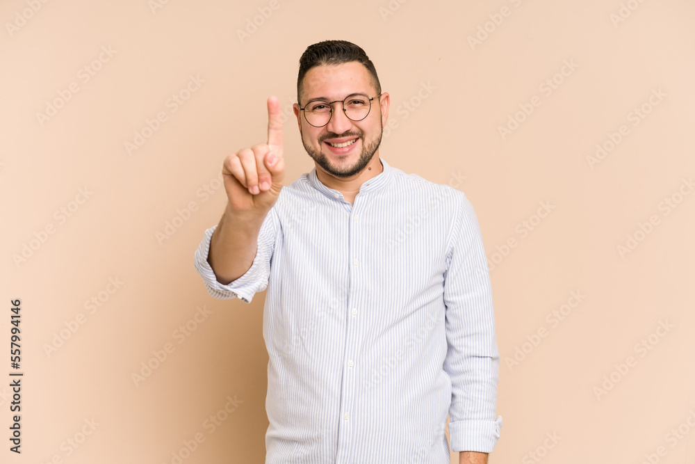 Adult latin man cut out isolated showing number one with finger. Adult latin man cut out isolated showing number one with finger.