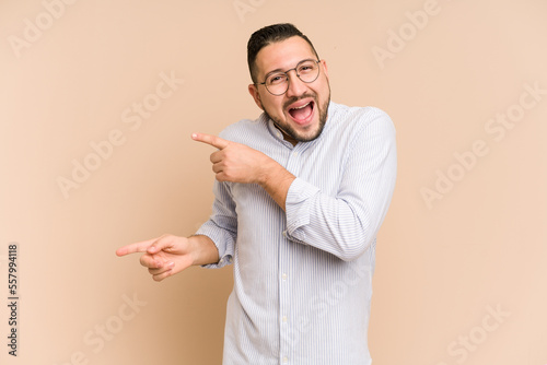 Adult latin man cut out isolated excited pointing with forefingers away.