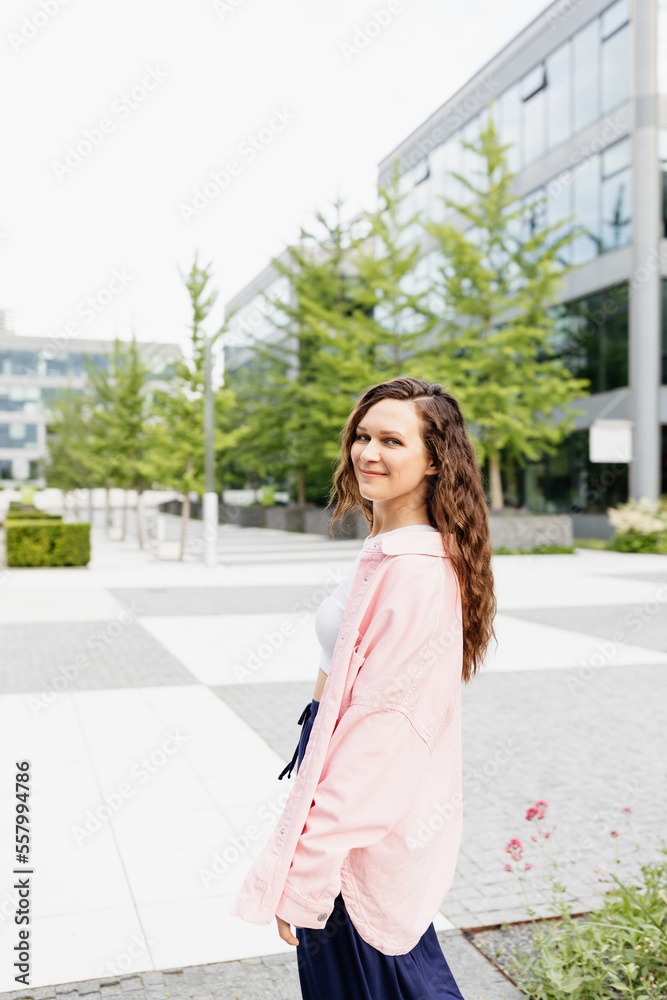 Happy pretty young brunette woman in pink oversized shirt
