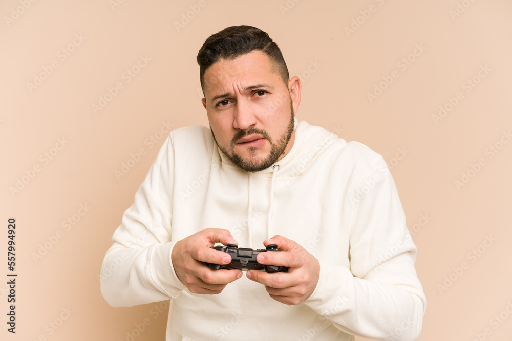 Adult latin man playing with a game controller isolated Adult latin man playing with a game controller isolated