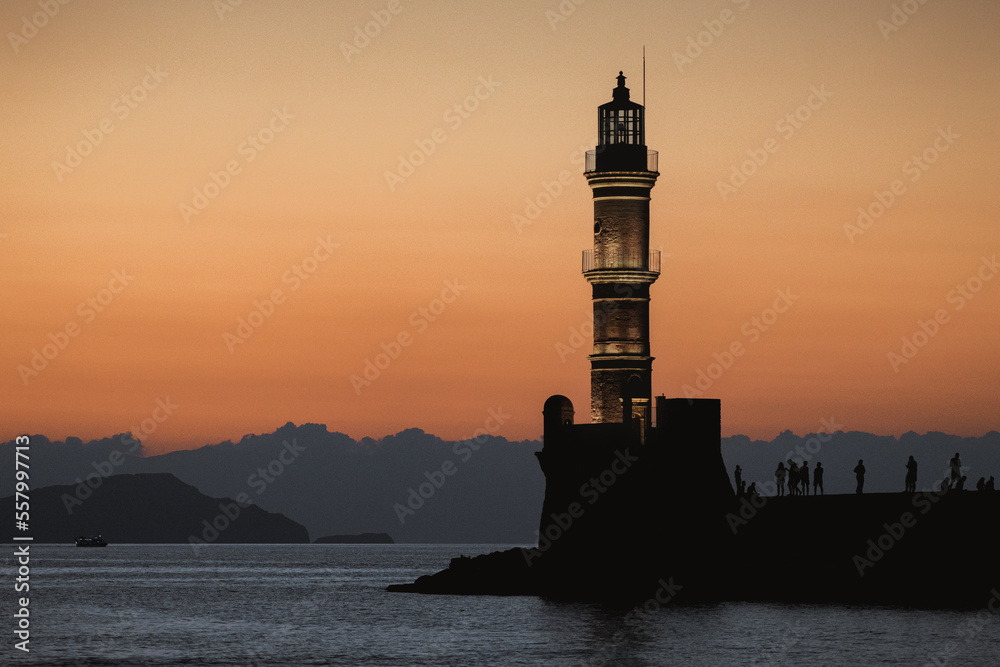 Chania, Greece, view of the old venetian lighthouse in the city harbour at sunset. 