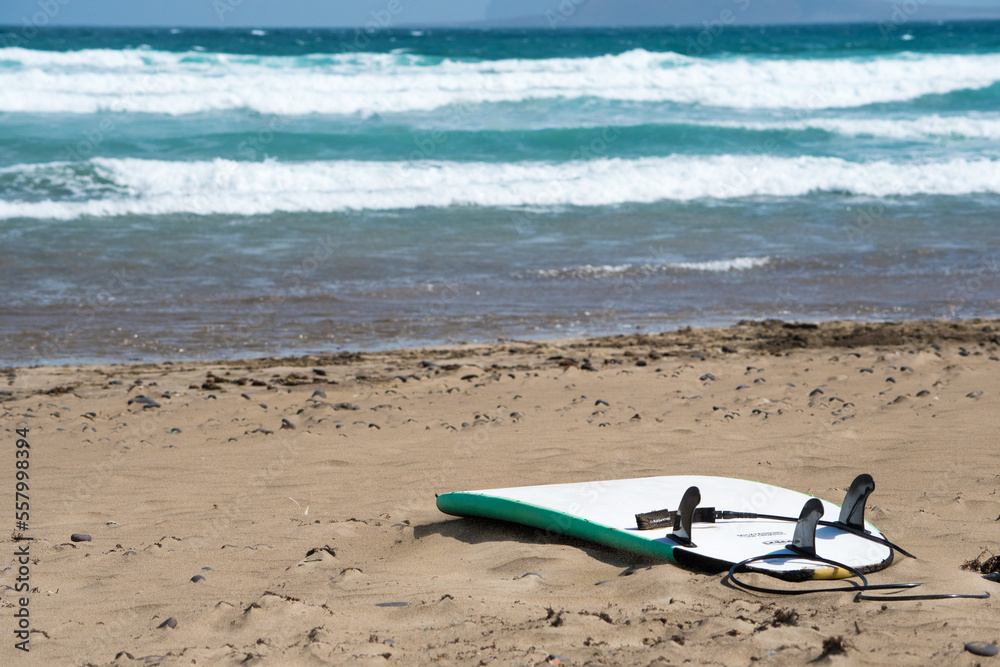 Surfboard At Beach facing the sea. Golden beach and waves in the background. Canary Island, Spain. Surfboard At Beach facing the sea. Golden beach and waves in the background. Canary Island, Spain.