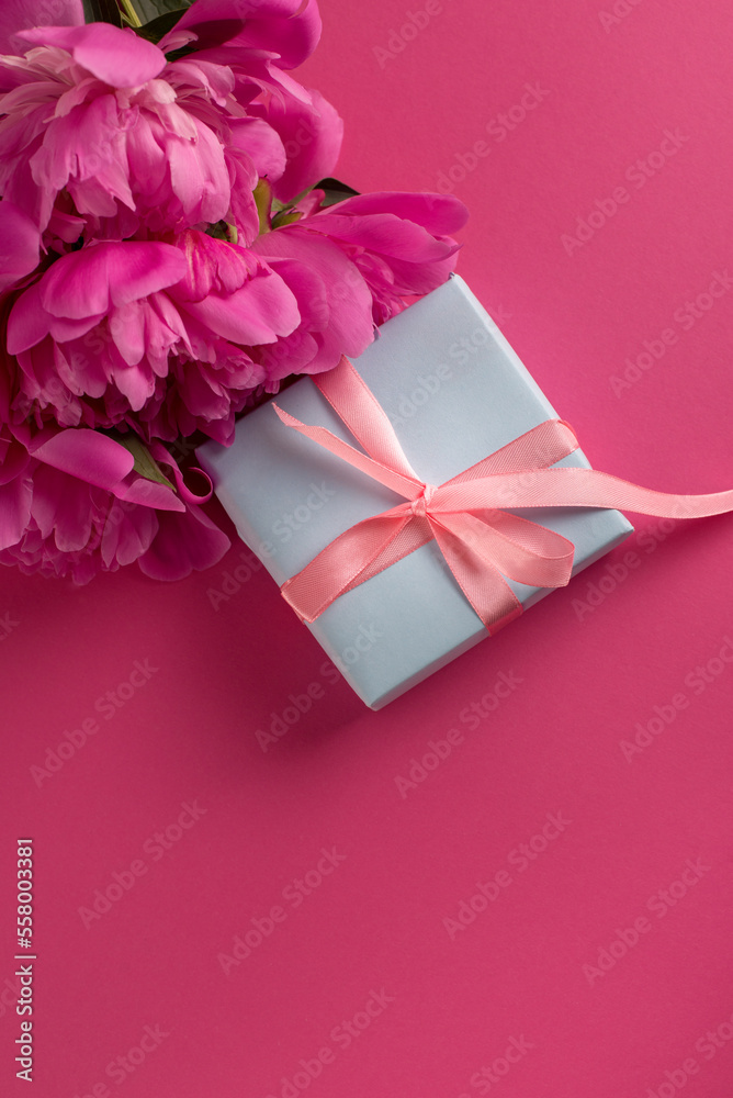 Valentine's Day Background with Pink Peonies and Gift Box With Satin Pink Bow on a Magenta Color Background. Valentine's Day Background with Pink Peonies and Gift Box With Satin Pink Bow on a Magenta Color Background.