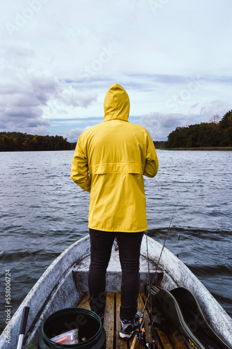 fisherman standing on boat in yellow rain jacket