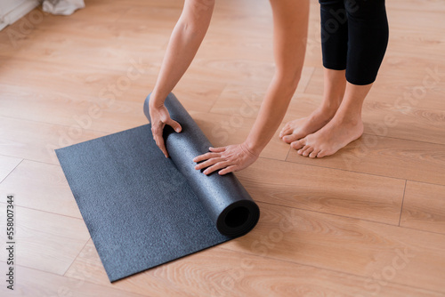 Cropped image of woman rolling yoga mat