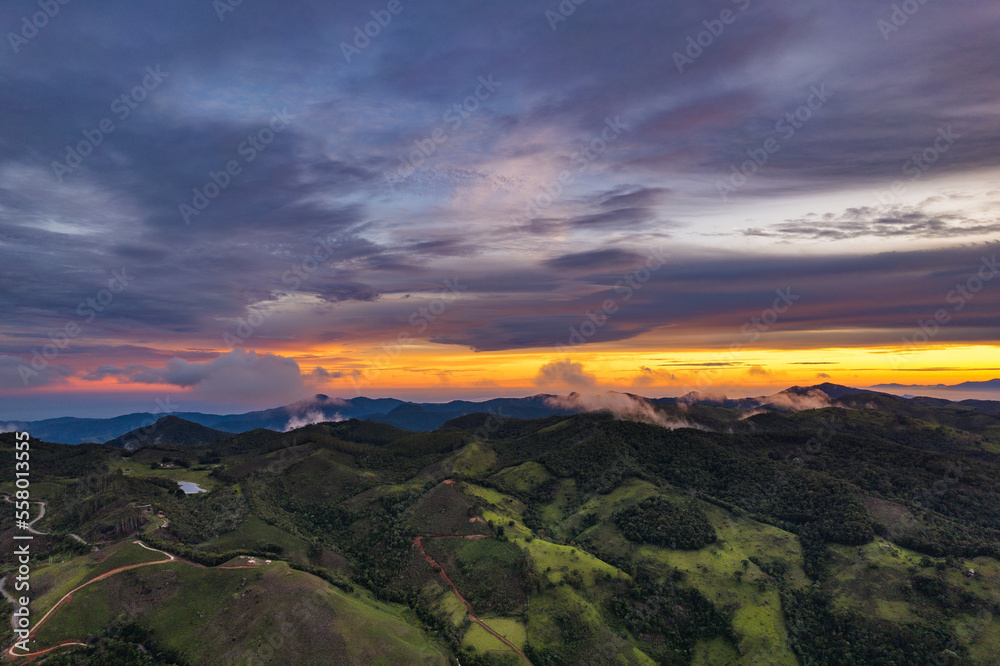 Aerial view of countryside landscape. Clouds with shades of purple, orange and green vegetation. Dramatic sky. Aerial view of countryside landscape. Clouds with shades of purple, orange and green vegetation. Dramatic sky.