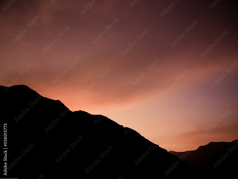 Silueta de montaña en atardecer colorido, cielo naranja, hora dorada Silueta de montaña en atardecer colorido, cielo naranja, hora dorada