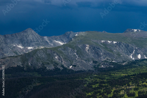 Fototapeta Naklejka Na Ścianę i Meble -  Snowy mountains surrounded by trees and rolling hills in Rocky Mountain National Park 