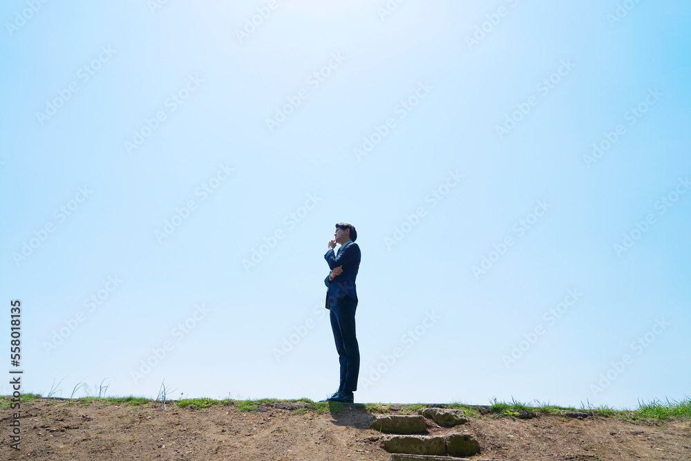 屋外で考えるビジネスマン　コピースペースあり