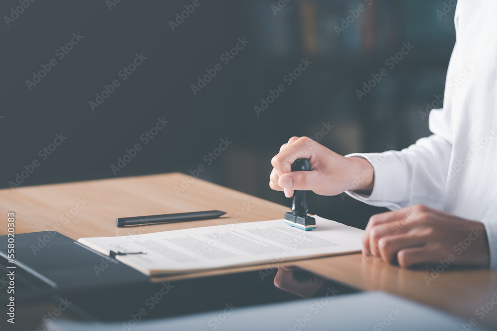 Fototapeta premium Businessman validates and manages business documents and agreements, signing a business contract approval of contract documents confirmation or warranty certificate,approval stamp.