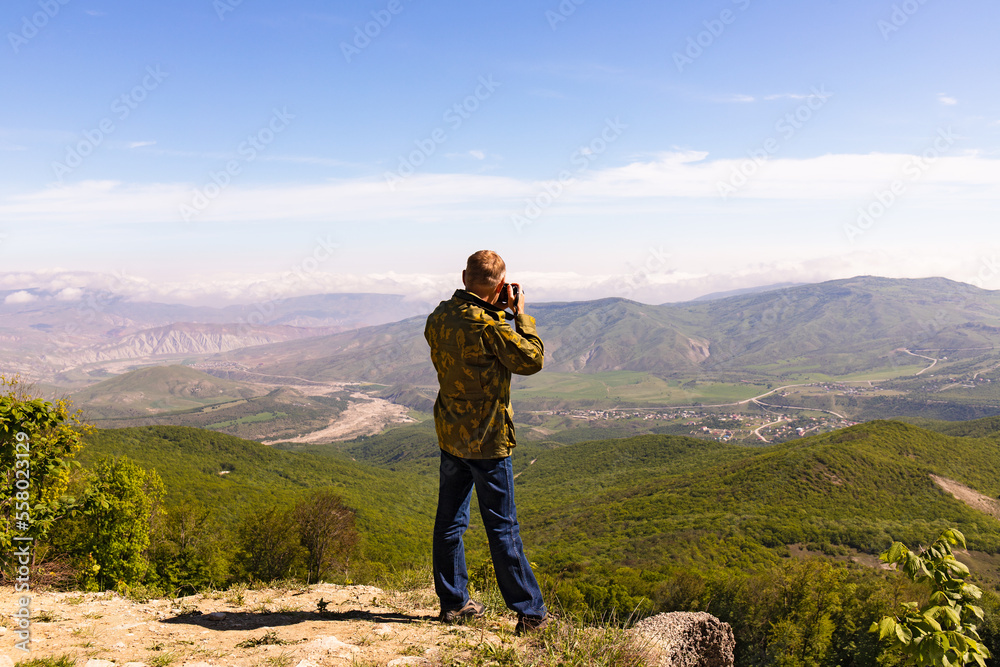 Photographer takes pictures of beautiful mountains. Khyzy region. Azerbaijan.