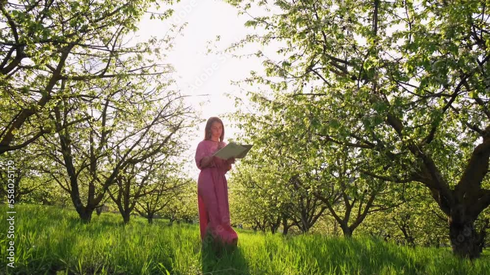 a girl at sunset paints in cherry orchards. The artist paints in the garden. Creative girl is painting a beautiful picture in the garden, holding a palette and brush, using tools to create a canvas. a girl at sunset paints in cherry orchards. The artist paints in the garden. Creative girl is painting a beautiful picture in the garden, holding a palette and brush, using tools to create a canvas.