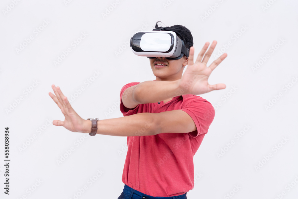 A young asian man explores a VR environment via a virtual reality headset. Isolated on a white backdrop.