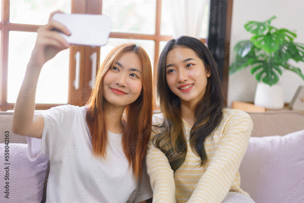 Activity at home concept, LGBT lesbian couple smiling and using smartphone to selfie together Activity at home concept, LGBT lesbian couple smiling and using smartphone to selfie together