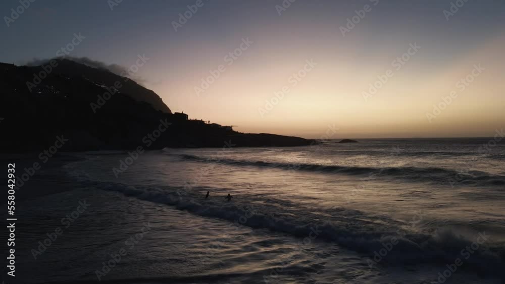 a couple playing with big waves at Sea over white sands of South African beach sunset time- aerial shot a couple playing with big waves at Sea over white sands of South African beach sunset time- aerial shot