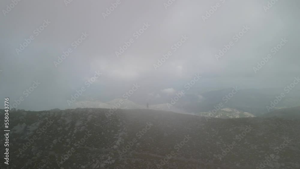 aerial view video zoom in of a man in middle of fog and some clouds over huge forests in Montenegro Lovcen. aerial view video zoom in of a man in middle of fog and some clouds over huge forests in Montenegro Lovcen.