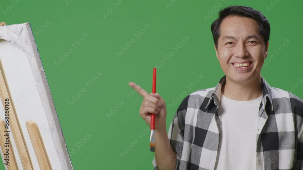 Close Up Of Asian Male Artist Pointing To The Canvas While Painting By Oil Paints And Brush In The Green Screen Studio
Close Up Of Asian Male Artist Pointing To The Canvas While Painting By Oil Paints And Brush In The Green Screen Studio