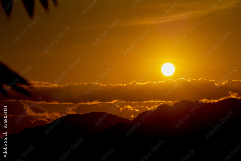 Sunset with sun over the cloud and mountain with warm yellow and orange light and give relax and happy emotion. Sunset with sun over the cloud and mountain with warm yellow and orange light and give relax and happy emotion.