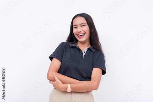 A young asian woman laughs from a joke while looking at the camera. A happy and lighthearted scene. Isolated on a white backdrop. © Mdv Edwards