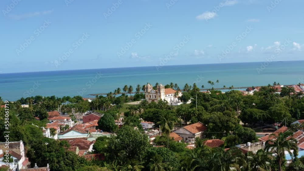 Dolly-in aerial drone shot approaching the beautiful historic church of Carmo in the center of the coastal tropical city of Olinda in Pernambuco, Brazil surrounded by residential homes and palm trees Dolly-in aerial drone shot approaching the beautiful historic church of Carmo in the center of the coastal tropical city of Olinda in Pernambuco, Brazil surrounded by residential homes and palm trees