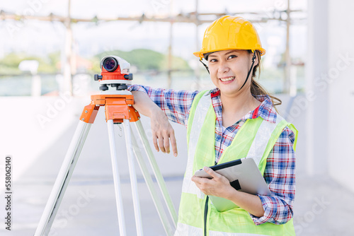 woman worker engineer with digital tablet survey equipment auto levelling camera happy smile