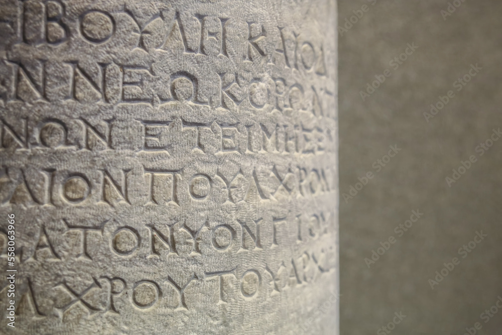Historical inscription. Fragment of ancient text (the law at Ancient Greek), carved on marble column. Bergama (Ancient Pergamon), Turkey (Turkiye). Ancient art and history concept. Retro background