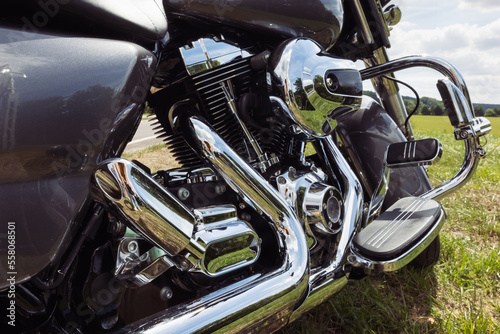 black motorcycle side view close-up ,motorbike stands on green grass isolated