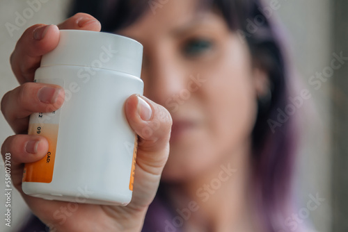 woman holding a bottle of vitamin supplements