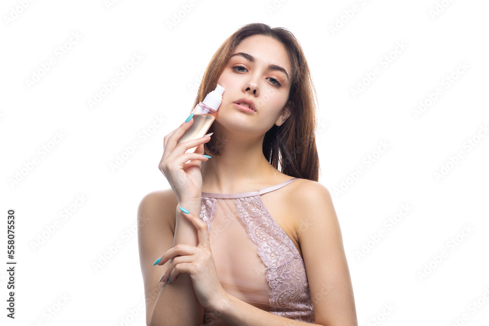 A beautiful sexy lady in an elegant nude bodysuit holds a bottle in her hands. Fashion beauty portrait of fashion model girl on isolated white background. A beautiful sexy lady in an elegant nude bodysuit holds a bottle in her hands. Fashion beauty portrait of fashion model girl on isolated white background.