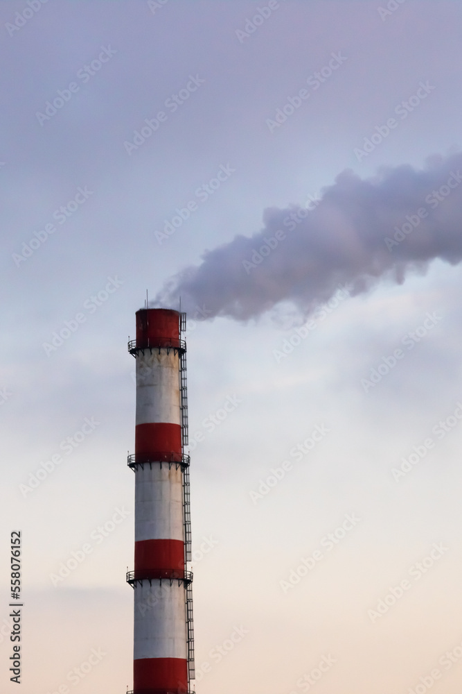 Gray smoke from the plant chimney at sunset