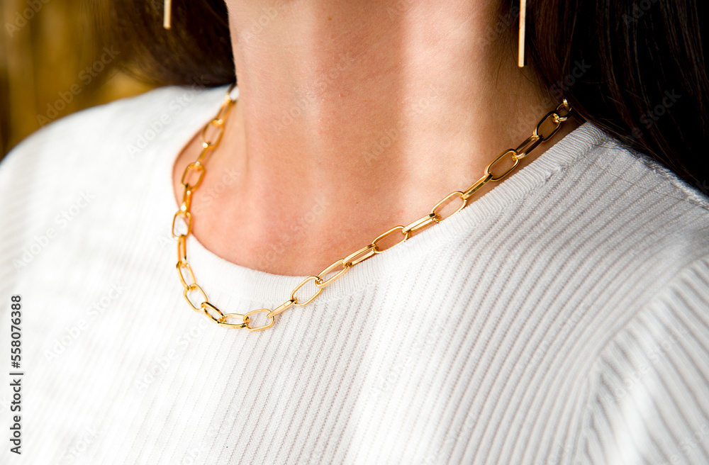close up woman with  gold necklace and earrings