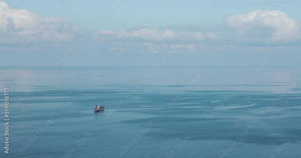 Cargo ship sailing on open sea. Aerial shot. Sky and sea. Cargo ship sailing on open sea. Aerial shot. Sky and sea.