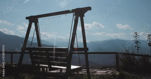 Wooden swing towards the mountain view.