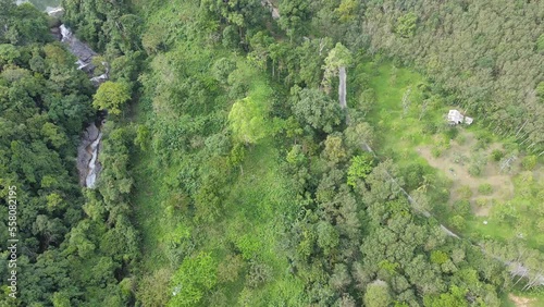 aerial view of green tree and waterfall flowing.beautiful and majestic nature in tropical rainforest.fly and rotate the camera over waterfall from top in bird eye view