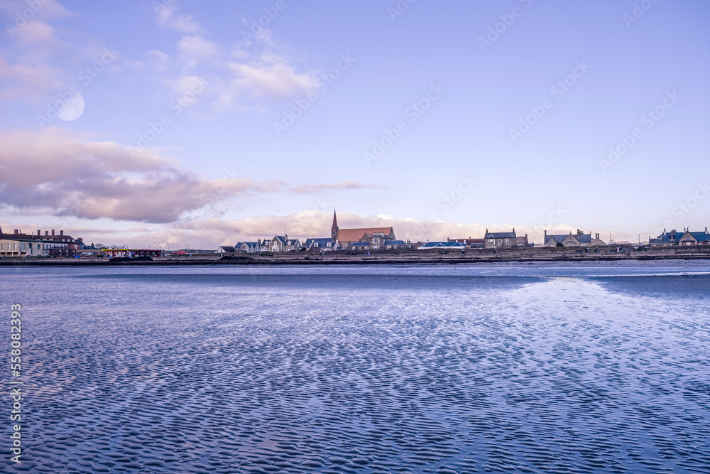 Looking up to the ancient town of Troon from the Bay Shore Line looking over the sand to the town and church spier