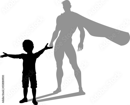 A superhero child or kid boy revealed by his shadow silhouette as a super hero in a cape.