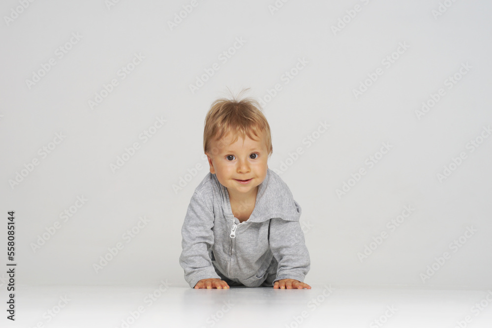 Little, happy and smiling cute baby in the studio. Portrait of a one year old baby. The concept of happiness. Little, happy and smiling cute baby in the studio. Portrait of a one year old baby. The concept of happiness.