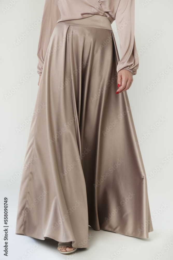 Studio shot of female fashion model in beige maxi circle skirt, Simplistic and elegant silk satin full length skirt