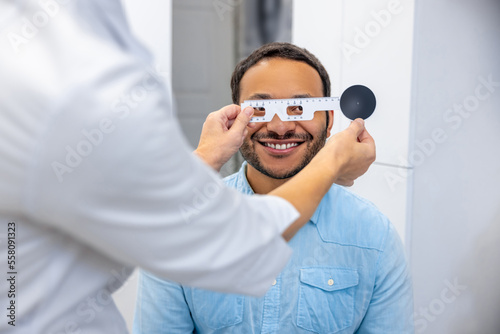 Dark-skinned smiling man having a visit to optometrist