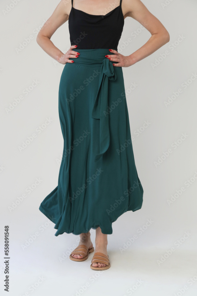 Serie of studio photos of young female model in comfortable yet stylish cotton outfit, black shit and emerald green skirt. Serie of studio photos of young female model in comfortable yet stylish cotton outfit, black shit and emerald green skirt.