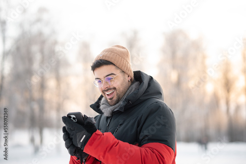 portrait of a man in winter forest getting good news on the phone