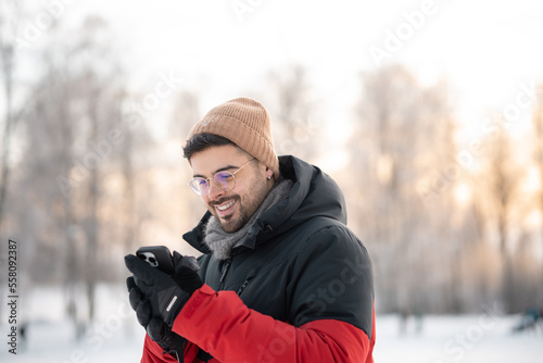 portrait of a man in winter forest getting good news on the phone