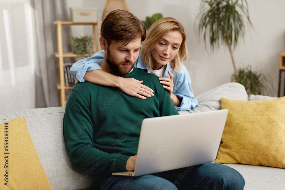 Couple Using Laptop Together. Husband And Wife Sharing Computer Social Network, Smiling And Searching For Funny Content. Technologies And People Concept Couple Using Laptop Together. Husband And Wife Sharing Computer Social Network, Smiling And Searching For Funny Content. Technologies And People Concept
