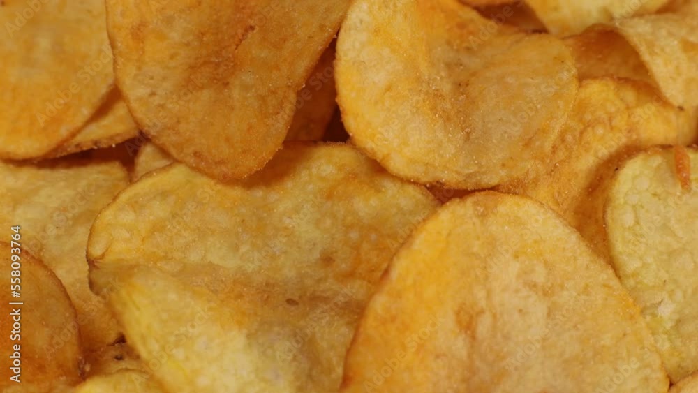 Crispy potato chips with cheddar cheese, rotating close up, macro Crispy potato chips with cheddar cheese, rotating close up, macro