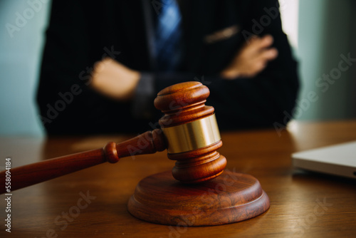 Business and lawyers discussing contract papers with brass scale on desk in office. Law, legal services, advice, justice and law concept picture with film grain effect