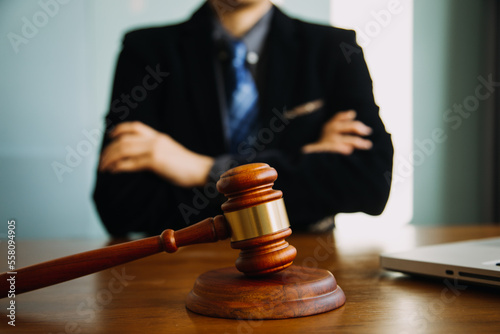 Business and lawyers discussing contract papers with brass scale on desk in office. Law, legal services, advice, justice and law concept picture with film grain effect